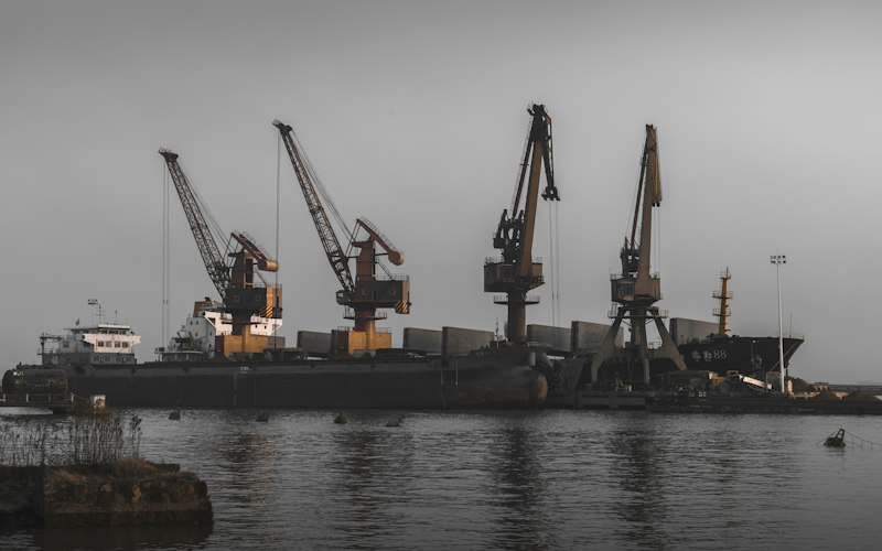 Heavy shipyard cranes working a vessel at a berth