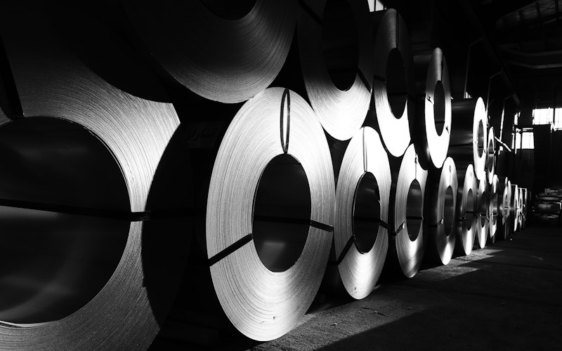 Steel coils lined up in a warehouse for plant transfer